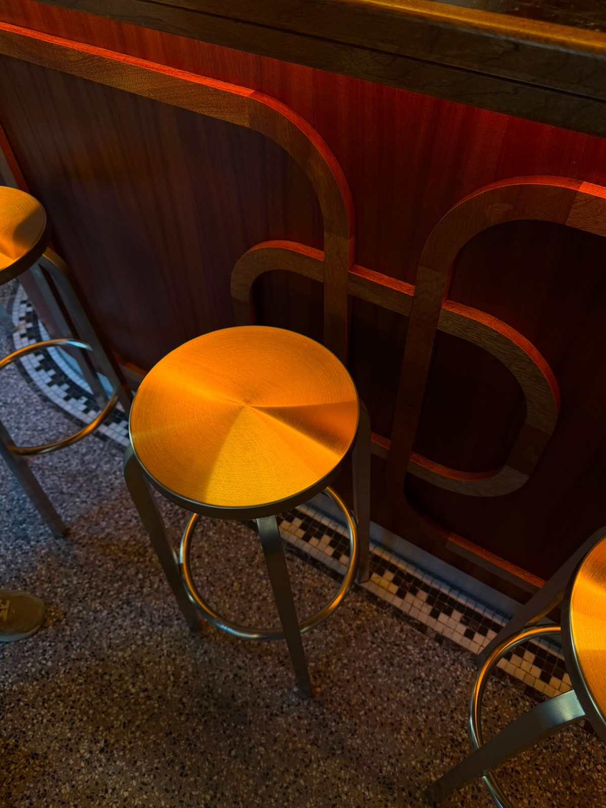Détail du bar en acajou de Monica : marqueterie années 60 et tabourets inox, Paris 6e