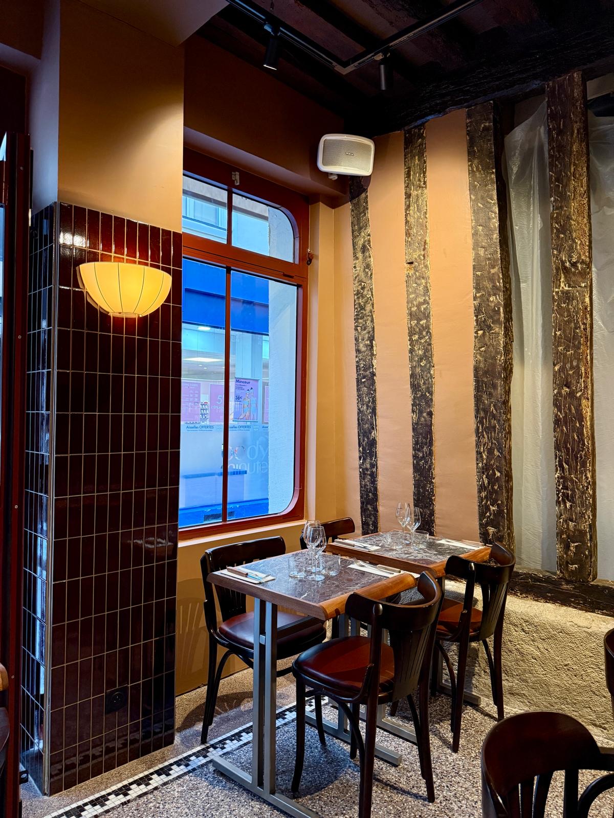 La salle de Monica : tables en marbre, carrelage bordeaux et colombages, rue Gozlin, Paris 6e